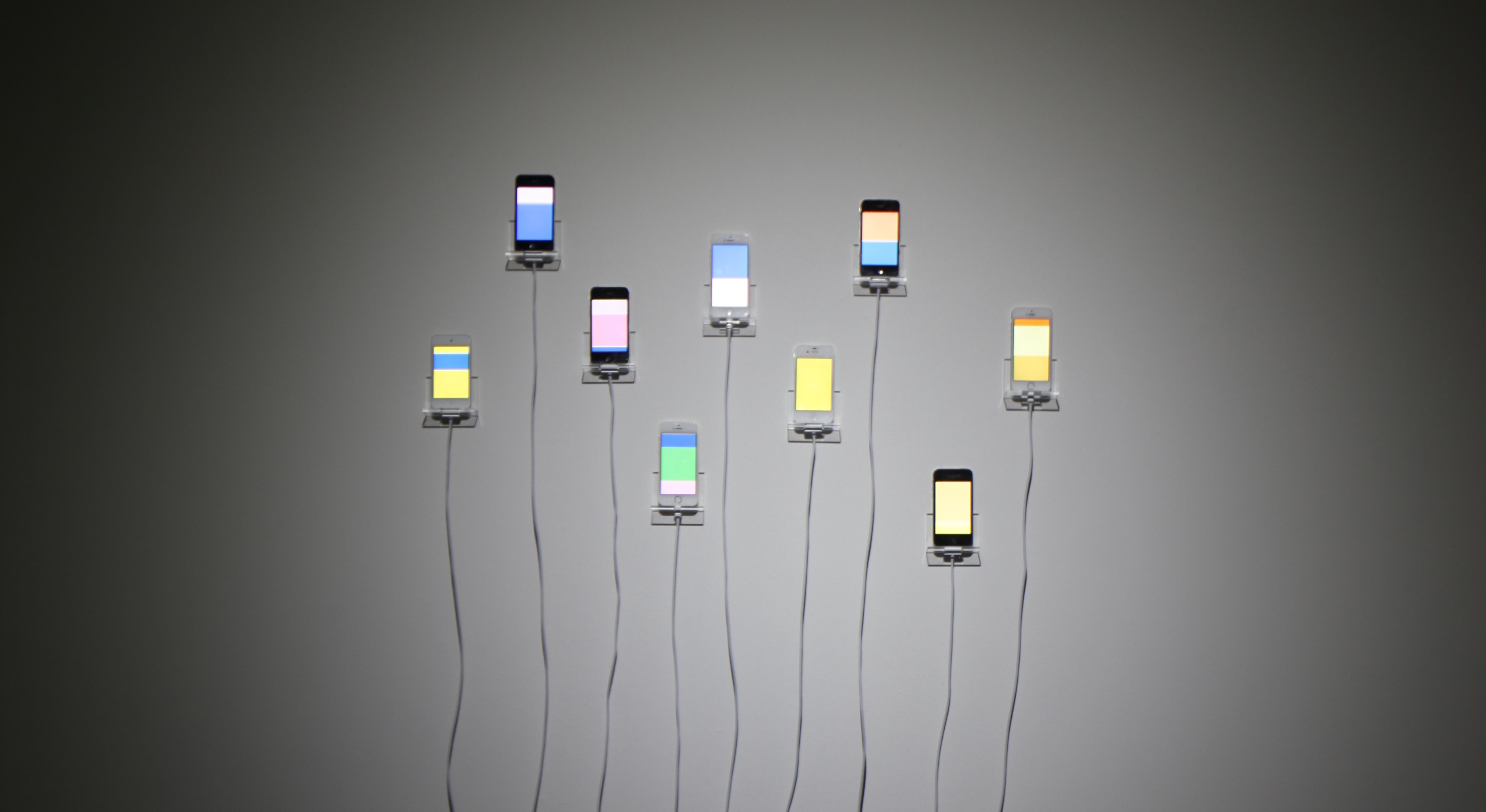 Nine iPhones mounted on the wall with nine unique motion sequences generated by different phone users