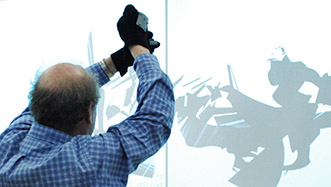 Man creating and drawing virtual marks on a projection screen using gestural tracking software