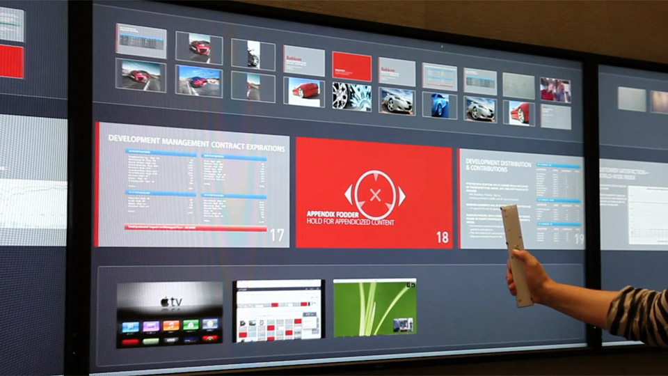 User demonstrating the pushback gesture to control a presentation with the Mezzanine wand, with feedback graphics on the screen